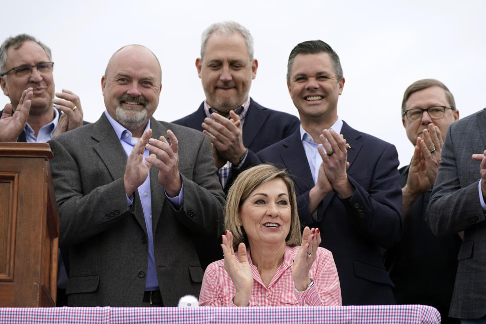 Iowa Gov. Kim Reynolds, center, react after signing the Biofuels Bill, Tuesday, May 17, 2022, in Prairie City, Iowa. (AP Photo/Charlie Neibergall)