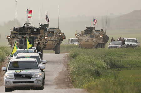 FILE PHOTO: Kurdish fighters from the People's Protection Units (YPG) head a convoy of U.S military vehicles in the town of Darbasiya next to the Turkish border, Syria April 28, 2017. REUTERS/Rodi Said/File Photo