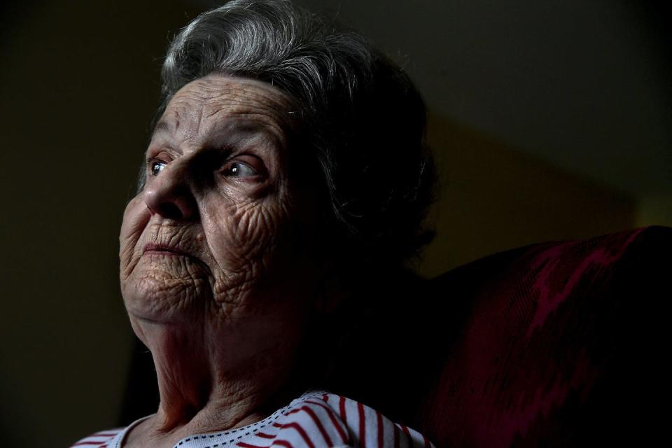 An older woman looks into the distance.