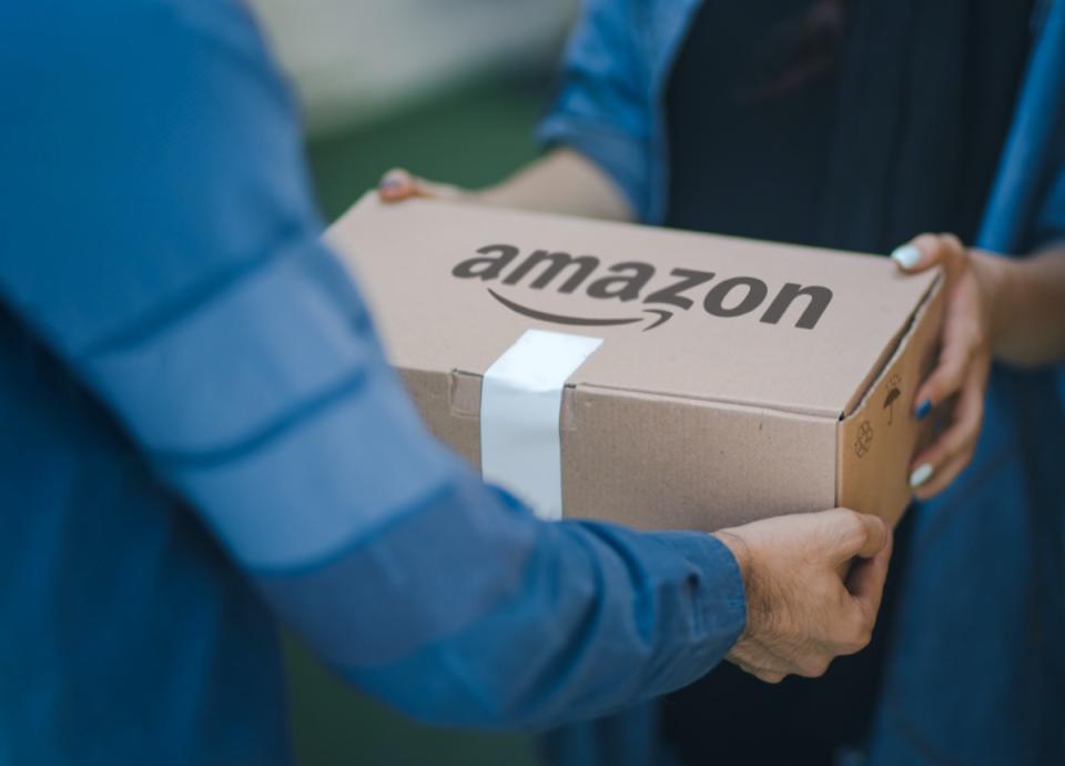 Malaga/Spain - 10-09-2020 : selective focus on man delivering parcel with amazon logo on cardboard
