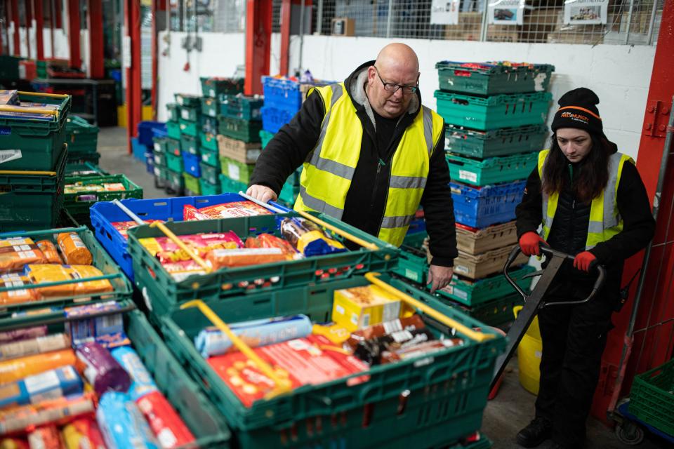 Workers at The Halo Centre, the central distribution point for donated items to be distributed to the Coventry Foodbank network of 14 sites across the city, collates food items into parcels that will be provided to people with a foodbank voucher, in Coventry, central England on January 23, 2023. - In Coventry, a city once home to a thriving car manufacturing industry, the 