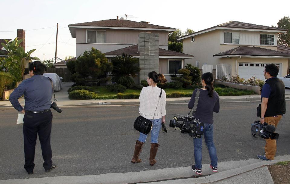 Japanese media wait outside the residence, left, of Dorian S. Nakamoto Thursday March 6, 2014, in Temple City, Calif. Nakamoto, the man that Newsweek claims is the founder of Bitcoin denies he had anything to do with it and says he had never even heard of the digital currency until his son told him he had been contacted by a reporter three weeks ago. (AP Photo/Nick Ut)