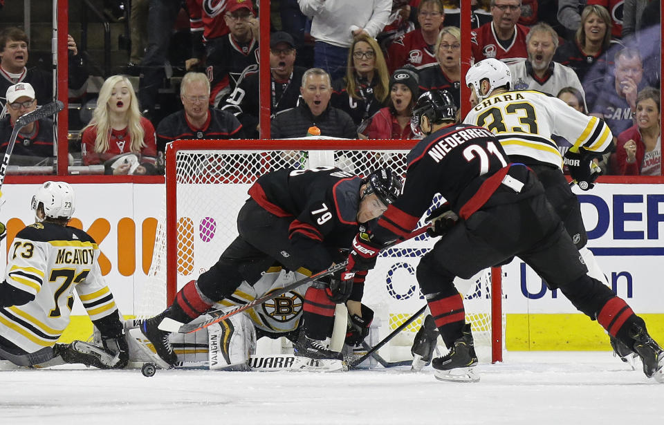 Carolina Hurricanes' Micheal Ferland (79) and Nino Niederreiter (21), of Switzerland, try to score against Boston Bruins goalie Tuukka Rask (40), of Finland, while Bruins' Zdeno Chara (33), of Slovakia, and Charlie McAvoy (73) defend during the first period in Game 3 of the NHL hockey Stanley Cup Eastern Conference final series in Raleigh, N.C., Tuesday, May 14, 2019. (AP Photo/Gerry Broome)