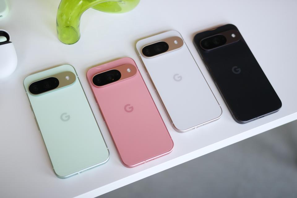 Google Pixel 9 dalam warna hijau, merah muda, putih, dan hitam, semuanya diletakkan di atas meja putih.