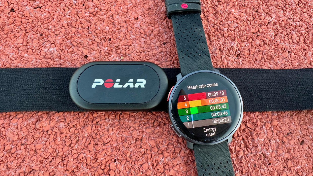  The Polar Vantage V3 and Polar H10 sitting on a track, with the watch showing heart rate zones. 