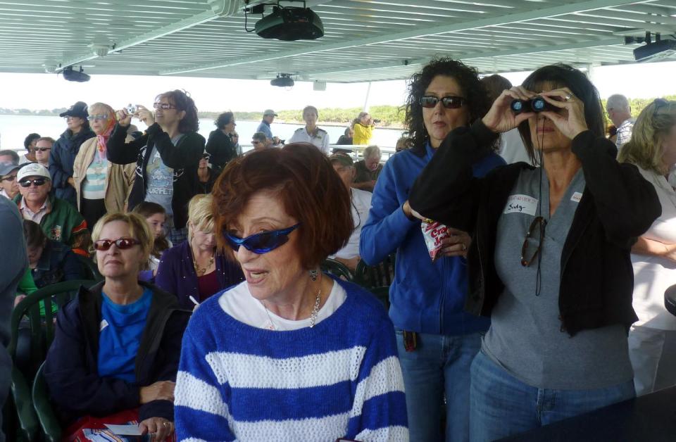 In this photo taken Sunday, Nov. 11, 2012, passengers view Stiltsville, a group of seven homes built on stilts in Biscayne National Park, Sunday, Nov. 11, 2012 in Miami. The narrated tour tells the colorful story of these homes perched above the shallow waters of Biscayne Bay. (AP Photo/Suzette Laboy)