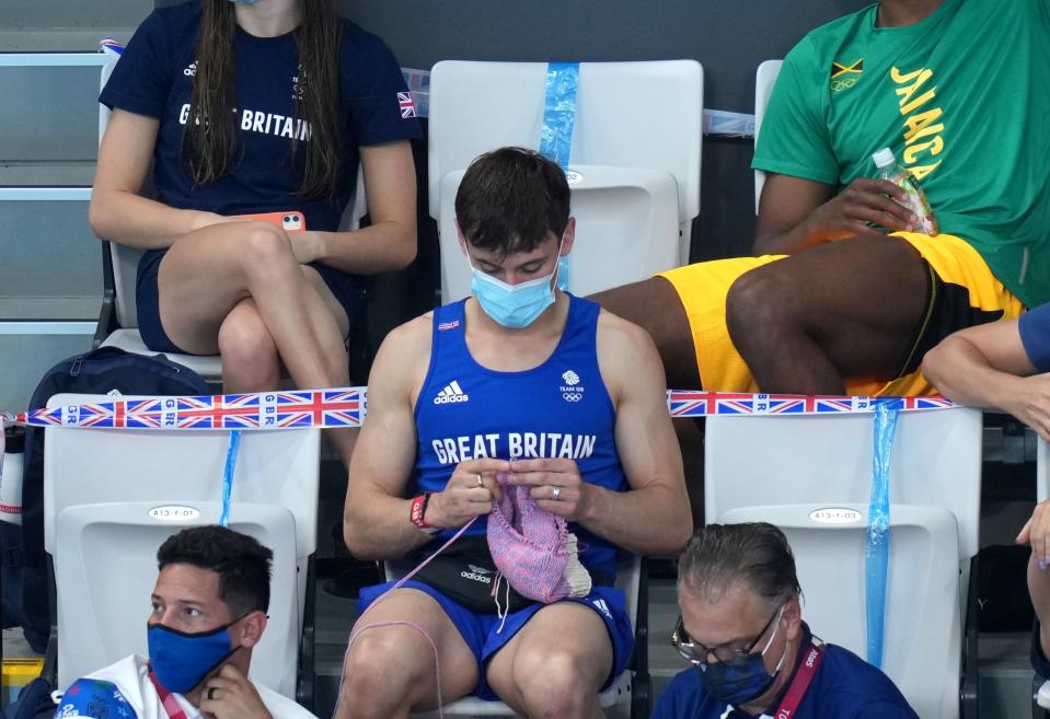 Tom Daley haciendo punto en las gradas del Centro Acuático de Tokio. (Foto: Joe Giddens / PA Images / Getty Images).