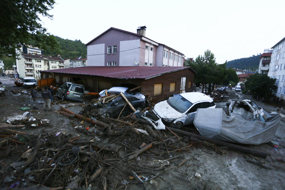 Destroyed cars in a street after floods and mudslides in Bozkurt town of Kastamonu province, Thursday, Aug. 12, 2021. The floods triggered by torrential rains battered the Black Sea coastal provinces of Bartin, Kastamonu, Sinop and Samsun on Wednesday, demolishing homes and bridges and sweeping cars away by torrents. Helicopters scrambled to rescue people stranded on rooftops.(IHA via AP)