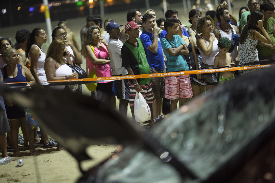 <p>People watch a car that has driven into the crowded seaside boardwalk along Copacabana beach in Rio de Janeiro, Brazil, Thursday, Jan. 18, 2018. (Photo: Silvia Izquierdo/AP) </p>