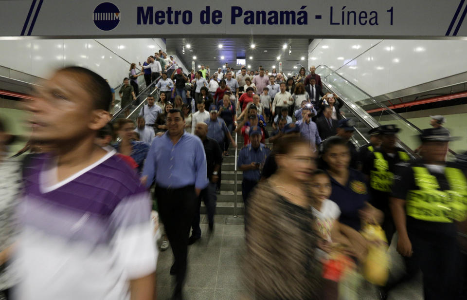 In this Wednesday, April 2, 2014 photo, government employees and their guests walk inside a subway station while participating in an invitation to test the wagons of the new Panama Metro in Panama City. Central America’s first underground metro will surely alleviate the booming capital’s dreadful traffic. But critics say the $2 billion spent on the 14-kilometer rail project, which was marred by cost overruns, would’ve been better used building a higher-capacity, surface transport network. They also are blasting the timing of the over-the-top inauguration set for Saturday, April 5, which they say is a political stunt by President Ricardo Martinelli to drum up support for his preferred successor. (AP Photo/Arnulfo Franco)