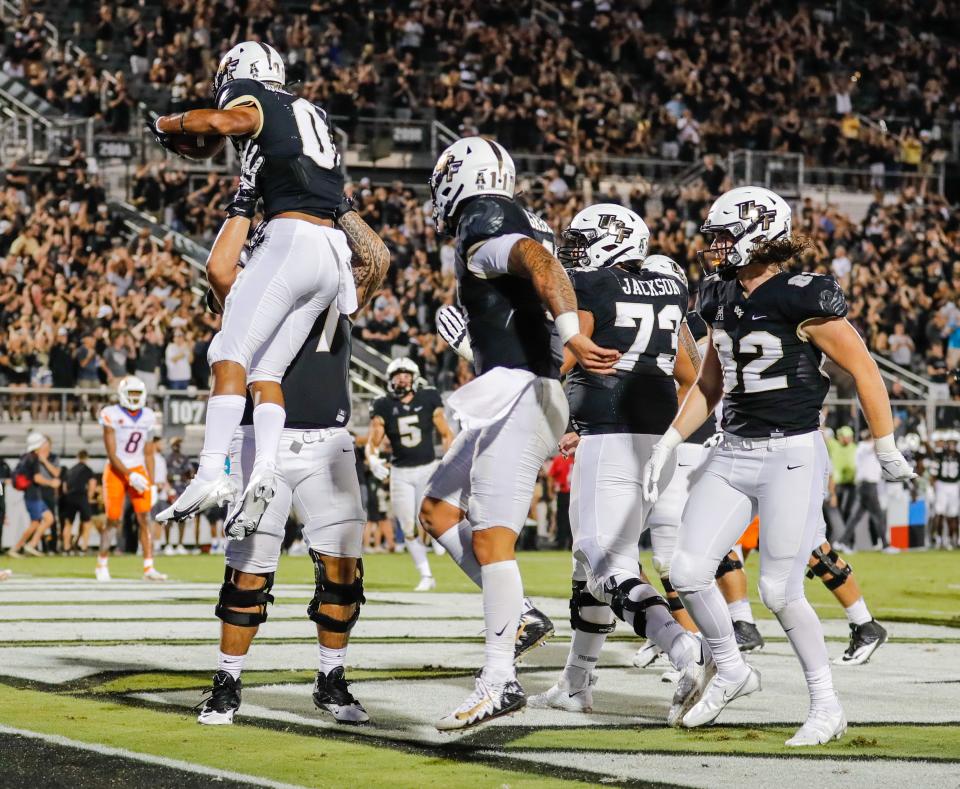 UCF Knights wide receiver Titus Mokiao-Atimalala is lifted into the air by teammates after scoring a touchdown against Boise State.