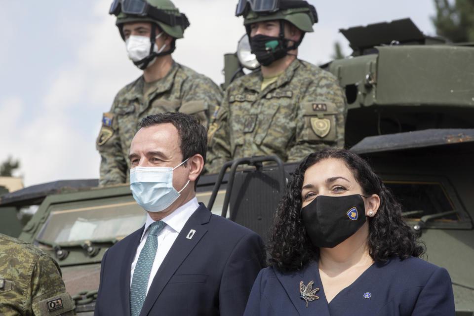 Kosovo president Vjosa Osmani, right, joined by prime minister Albin Kurti, left pose in front of Kosovo Security Force soldiers on top of armored security vehicle donated by U.S during a handout ceremony in the military barracks Adem Jashari in capital Pristina on Monday, Aug. 30, 2021. U.S as the main suppliers of Kosovo's defense the U.S donated 55 armored security vehicles to Kosovo Army. (AP Photo/Visar Kryeziu)