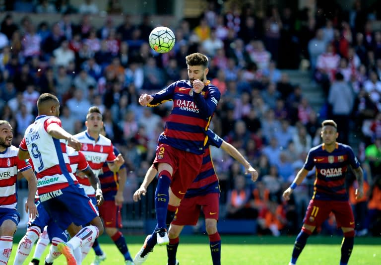 Barcelona's defender Gerard Pique (C) heads the ball during the Spanish league football match Granada CF vs FC Barcelona at Nuevo Los Carmenes stadium in Granada on May 14, 2016