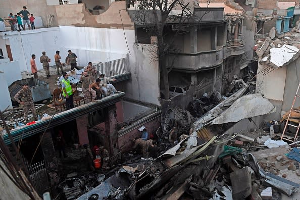 Security personnel search for victims in the wreckage of a Pakistan International Airlines aircraft after it crashed in a residential area in Karachi.