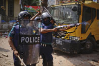 Security officers disperse demonstrators protesting against the visit of Indian Prime Minister Narendra Modi after Friday prayers at Baitul Mokarram mosque in Dhaka, Bangladesh, Friday, March 26, 2021. Witnesses said violent clashes broke out after one faction of protesters began waving their shoes as a sign of disrespect to Indian Prime Minister Narendra Modi, and another group tried to stop them. Local media said the protesters who tried to stop the shoe-waving are aligned with the ruling Awami League party. The party criticized the other protest faction for attempting to create chaos in the country during Modi’s visit. (AP Photo/Mahmud Hossain Opu)