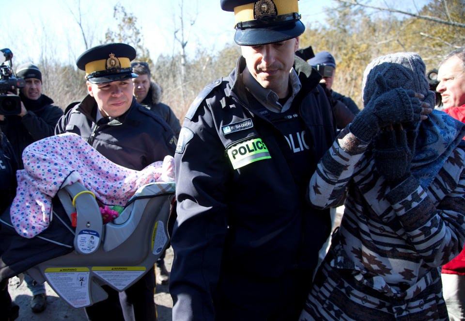 <p>A mother and her child are taken into custody by Royal Canadian Mounted Police officers after crossing the U.S.-Canada border into Hemmingford, Quebec, Canada, Feb. 20, 2017. (Christinne Muschi/Reuters) </p>