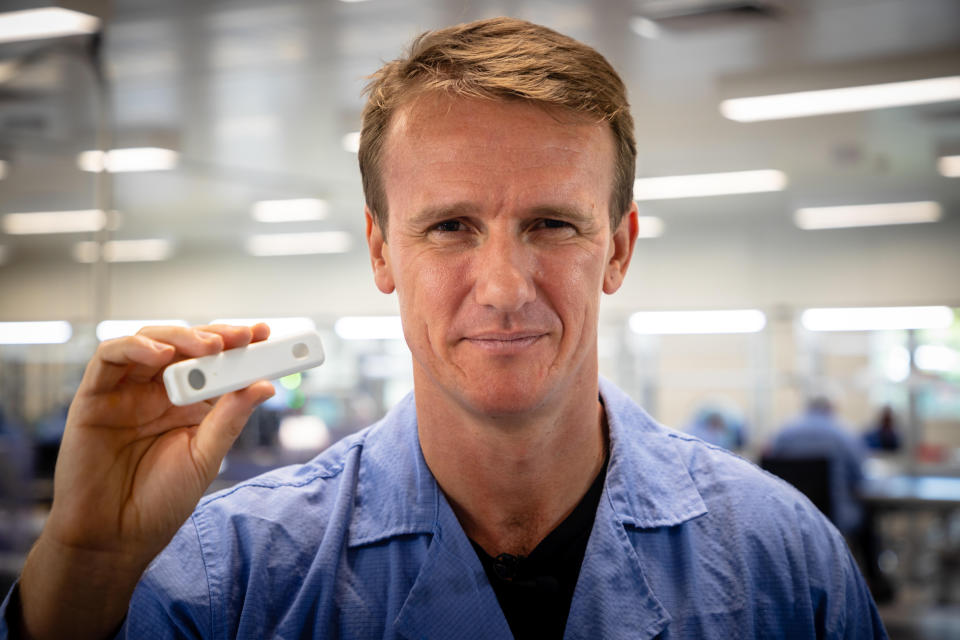 In this picture taken on December 21, 2020, Sean Parsons, founder and CEO of Australian digital diagnostics company Ellume, poses with a COVID-19 coronavirus home test unit that has been granted Emergency Use Authorization (EUA) by the US Food and Drug Administration (FDA), at the company's production facility in Brisbane. - Ellume's product delivers results in just 15 minutes and will soon be available over the counter in pharmacies across the country worst-hit by the pandemic. (Photo by Patrick HAMILTON / AFP) / To go with AFP story Health-virus-test-Australia-US, FOCUS by Holly Robertson (Photo by PATRICK HAMILTON/AFP /AFP via Getty Images)