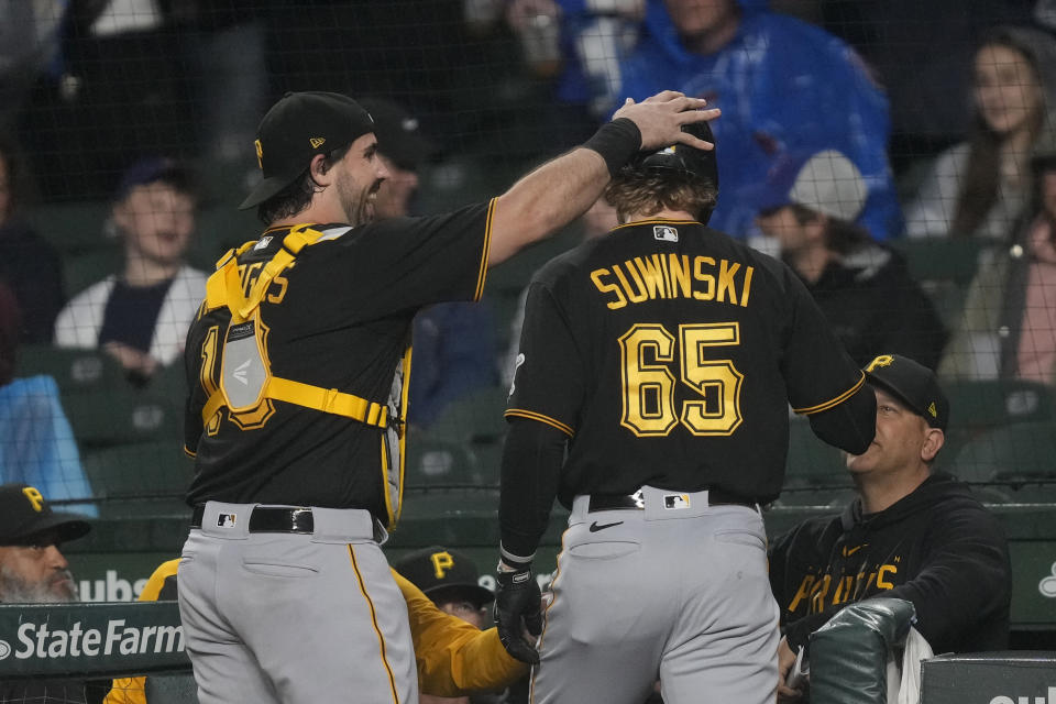 Pittsburgh Pirates' Jack Suwinski is congratulated outside the dugout by catcher Austin Hedges after his home run off Chicago Cubs starting pitcher Jameson Taillon during the first inning of a baseball game Tuesday, June 13, 2023, in Chicago. (AP Photo/Charles Rex Arbogast)