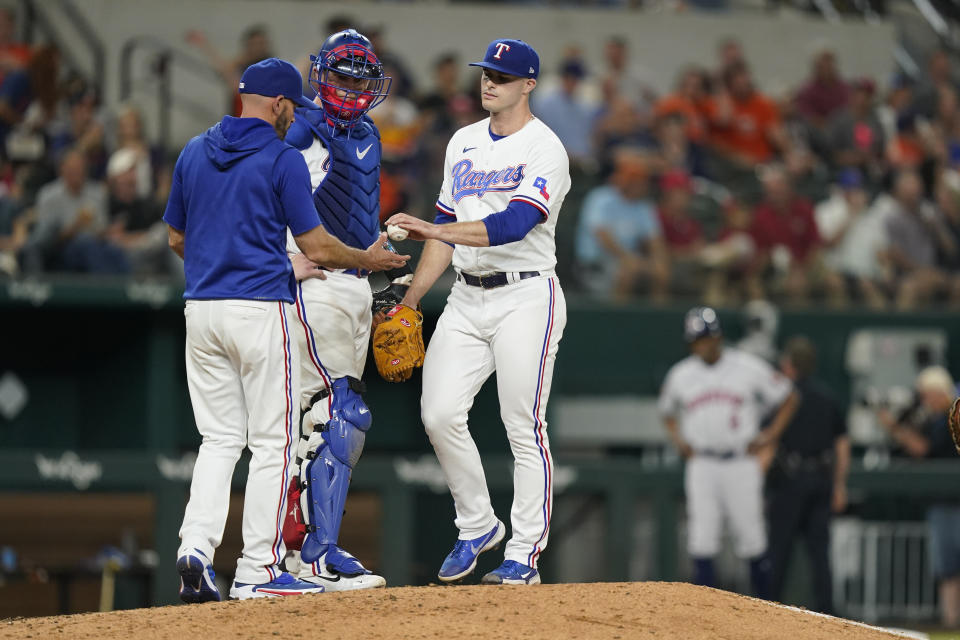 Texas Rangers relief pitcher John King, right, is pulled from the baseball game by manager Chris Woodward (8 as catcher Sam Huff stands on the mound during the eighth inning against the Houston Astros in Arlington, Texas, Tuesday, June 14, 2022. (AP Photo/LM Otero)