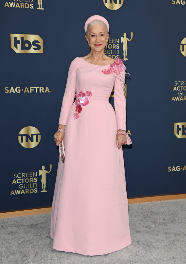 a floor-length, long-sleeved dress in a happy color with shiny flowers on the waist and shoulder, worn with a matching chunky headband