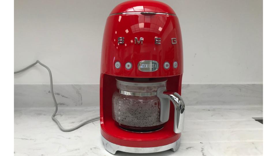 The red smeg drip coffee maker on a marble countertop