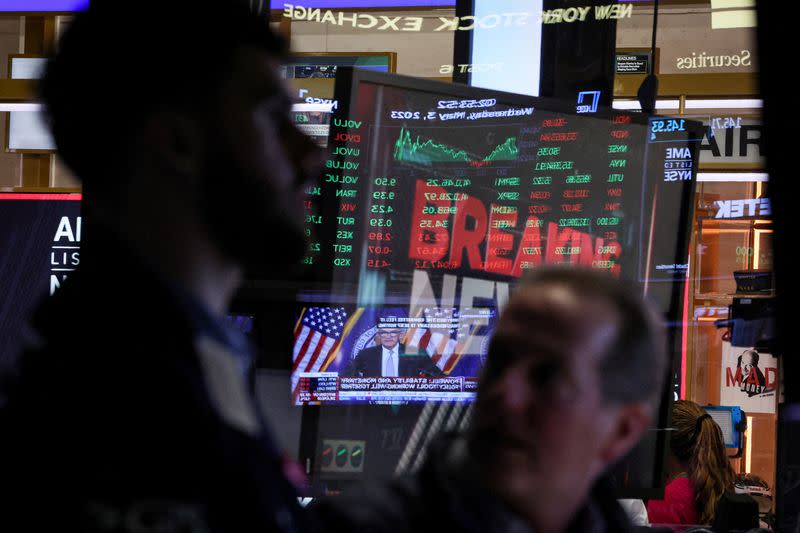 FILE PHOTO: Traders react as Federal Reserve Chair Jerome Powell is seen delivering remarks on a screen on the floor of the NYSE in New York