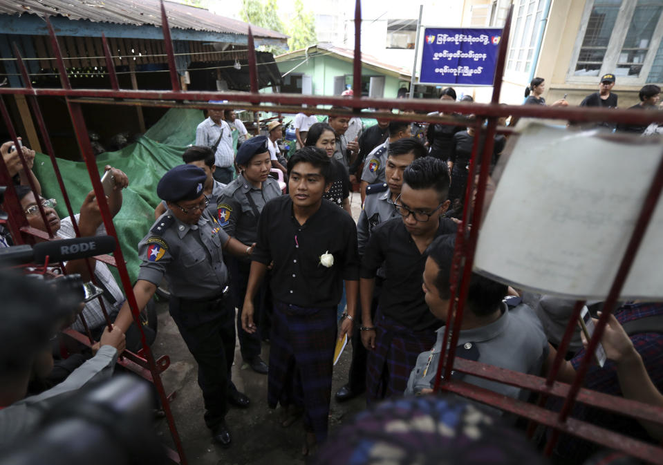 Zayar Lwin, center left, member of Student Union and a leader of Peacock Generation "Thangyat" Performance Group, talks as he leaves a township court along with his colleague Paing Phyo Min, right, after their trial Wednesday, Oct. 30, 2019, in Yangon, Myanmar. Zayar Lwin and others were charged with one year of hard labor for a satirical performance against the military earlier this year. (AP Photo/Thein Zaw)