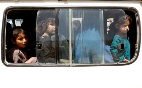 Afghan children ride in a vehicle as they flee their houses following heavy fighting in Ghazni Province - Credit: REUTERS/Mohammad Ismail