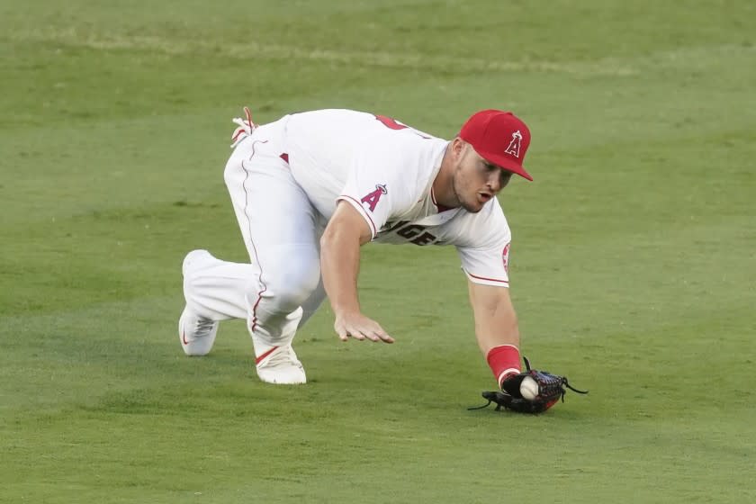 Los Angeles Angels center fielder Mike Trout reaches to catch a ball hit by Texas Rangers' Isiah Kiner-Falefa.