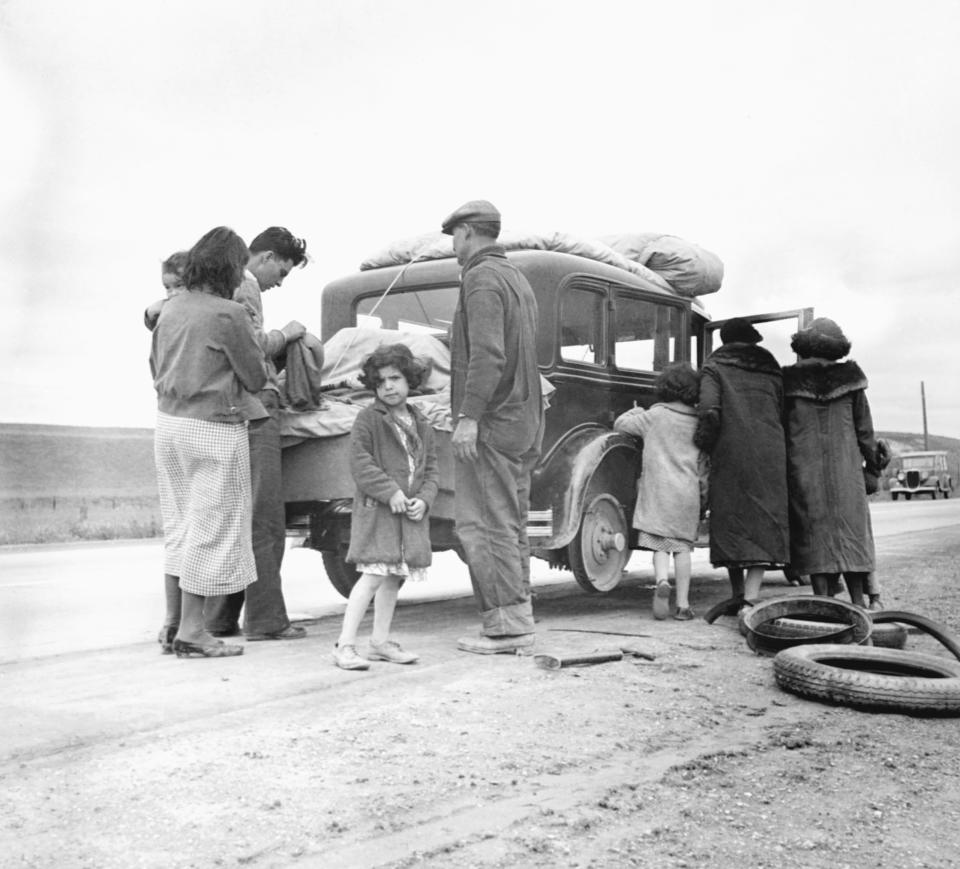 Migrant family from Mexico fixing a tire in California, February 1936. | Corbis via Getty Images