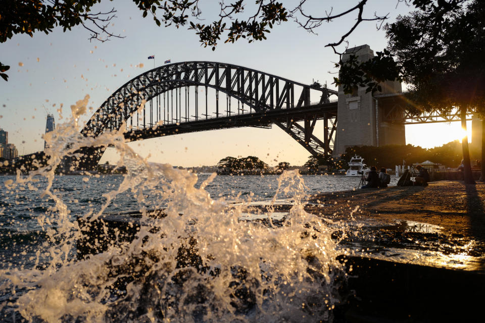 Water splashes over the edge of the harbour during the sunset in the suburb of Kiribilli on August 30, 2020 in Sydney, Australia