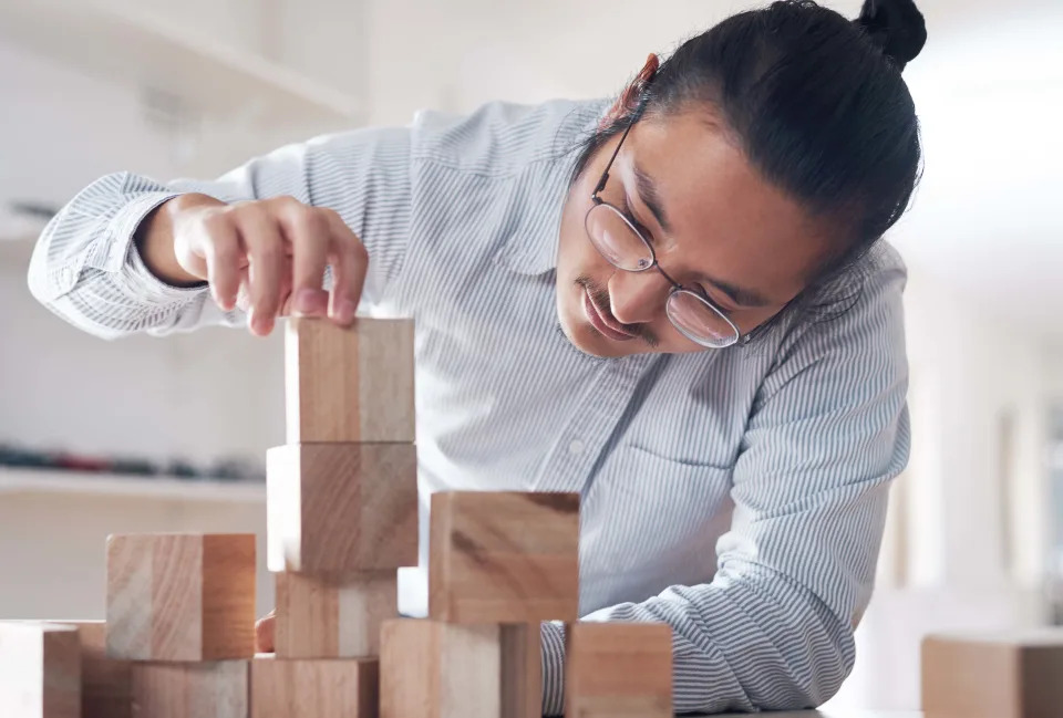 Businessman working with building blocks in the office. Photo: iStock