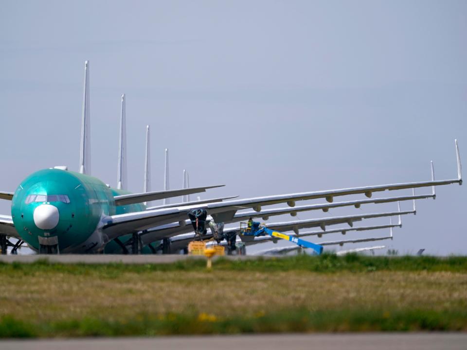 Boeing 777X parked in front of a line of planes.