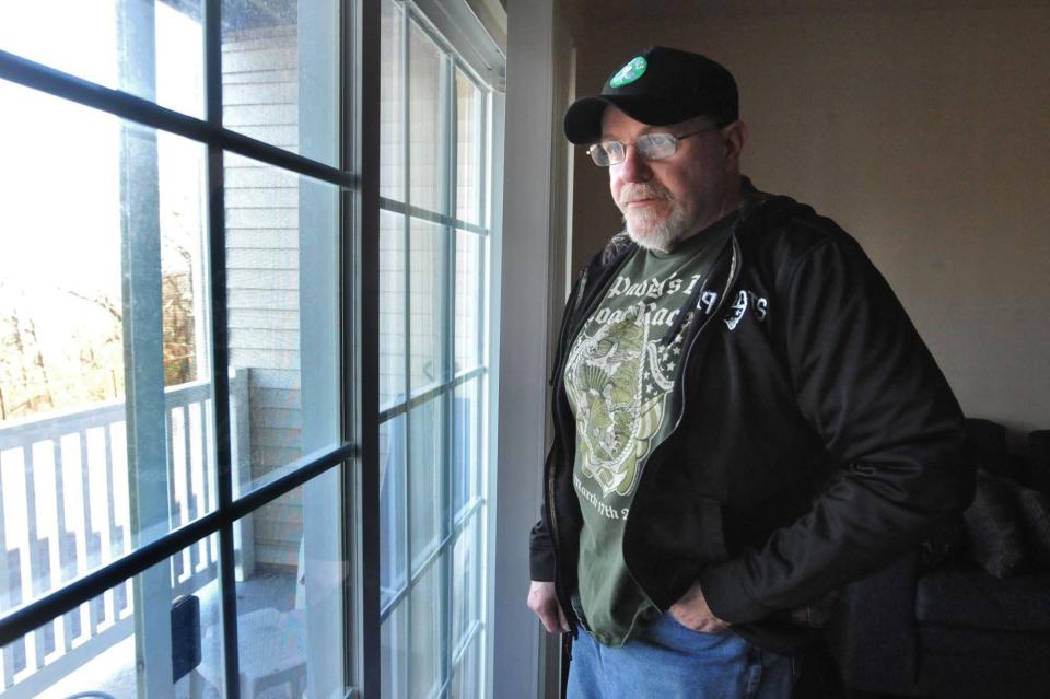 Jim Mac looks out the window of his Quincy apartment. His depression and anxiety make it difficult for him to go outside. Saturday, Dec. 23, 2023.
