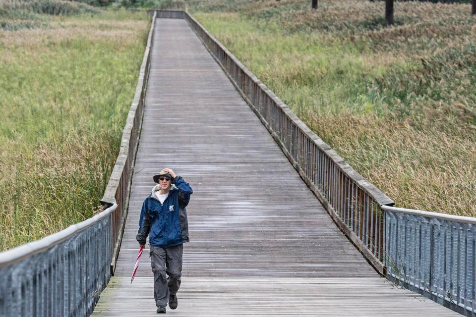 Michael Luyben came prepared for the rain on his customary walk and hangs on to his hat against the winds brought on by Tropical Storm Ophelia at the Jack A. Markell Trail in Wilmington, Saturday, September 23, 2023. Wilmington saw intermittent winds, rain and drizzle.