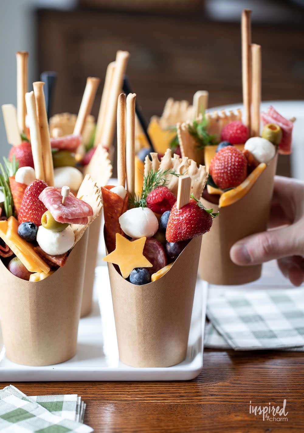 a tray of charcuterie cups with cheese, fruit and meat