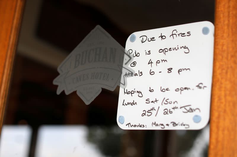 Signage alerting customers to altered opening hours due to bushfires is seen on the doorway of the Buchan Caves Hotel in Buchan, Victoria, Australia