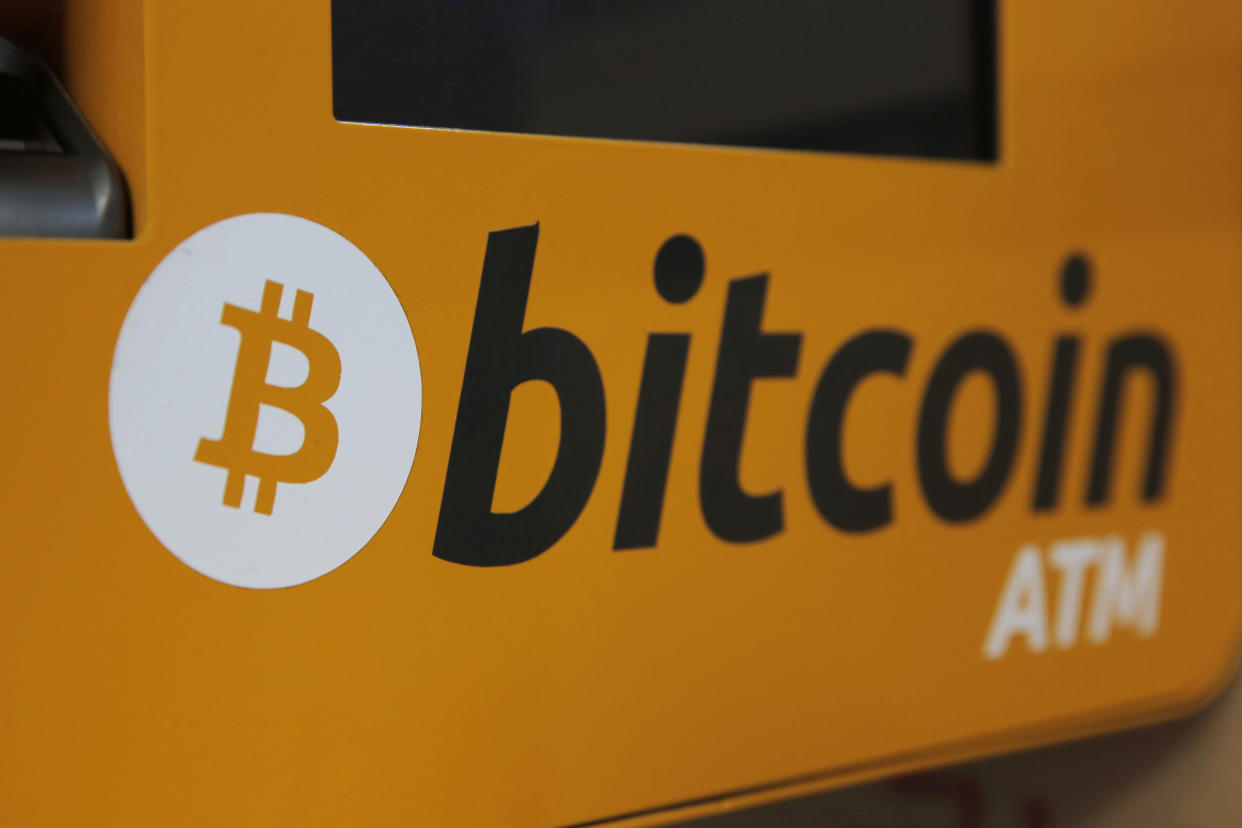 FILE - A Bitcoin logo is displayed on an ATM in Hong Kong, Thursday, Dec. 21, 2017. Britain has unveiled plans to regulate some stablecoins as part of a broader plan to become a global hub for digital payments, as authorities in the U.S. and Europe race to draw up rules for cryptocurrencies. The British Treasury said Monday, April 4, 2022, that it would also work with the Royal Mint to create a digital collectible known as an NFT and introduce a set of measures aimed at attracting cryptocurrency companies. (AP Photo/Kin Cheung, File)