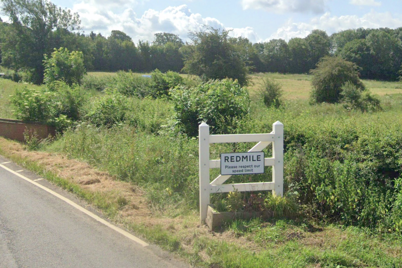 A sign saying 'Redmile - please respect our speed limit' is attached to a decorative gate.