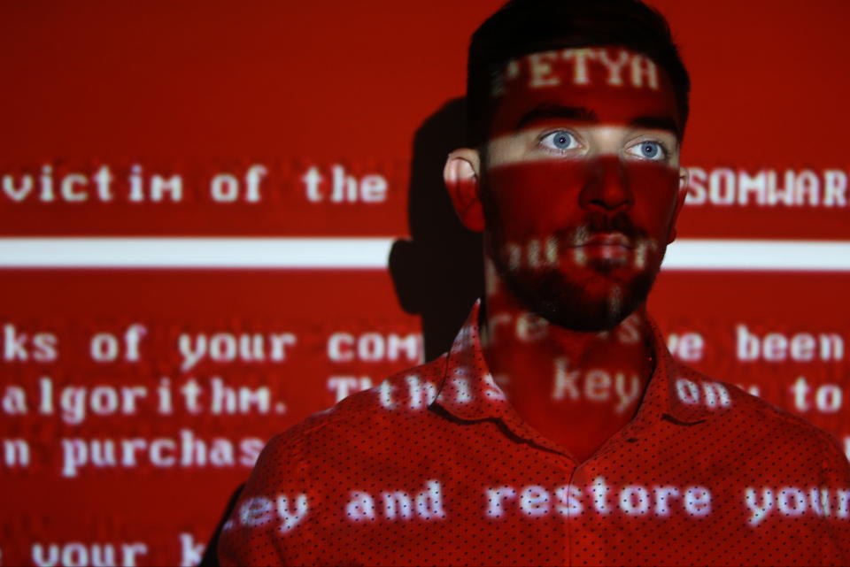 RYAZAN, RUSSIA - JUNE 28, 2017: A message related to the Petya ransomware projected on a young man; on 27 June 2017 a variant of the Petya ransomware virus hit computers of companies in Russia, Ukraine, and other countries in a cyber attack. Alexander Ryumin/TASS (Photo by Alexander Ryumin\TASS via Getty Images)