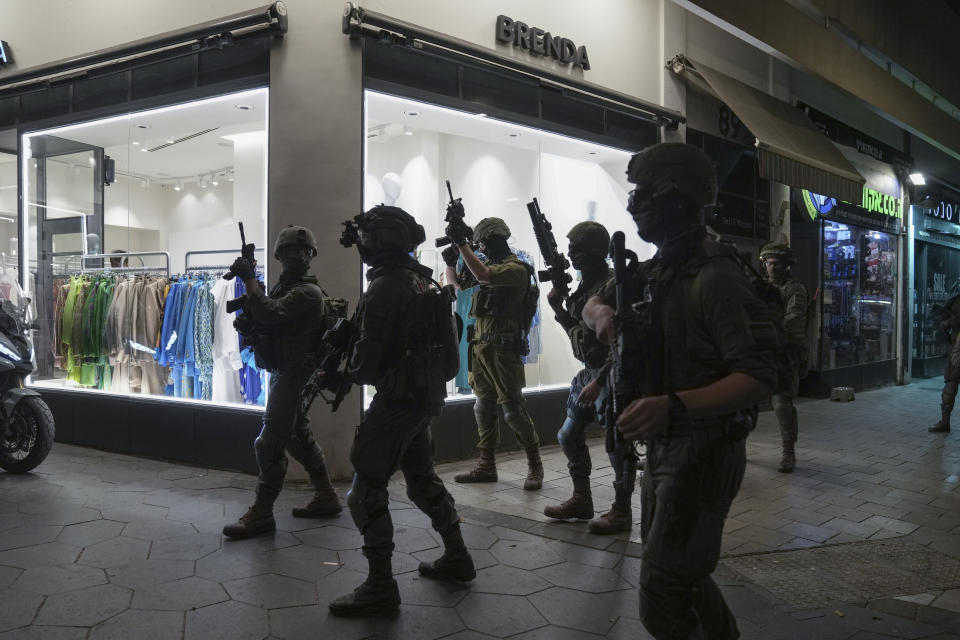 Israeli security forces search for assailants near the scene of a shooting attack in Tel Aviv, Israel, Thursday, April 7, 2022. Israeli health officials say two people were killed and at least eight others wounded in a shooting in central Tel Aviv. The shooting on Thursday evening, the fourth attack in recent weeks, occurred in a crowded area with several bars and restaurants. (AP Photo/Ariel Schalit)