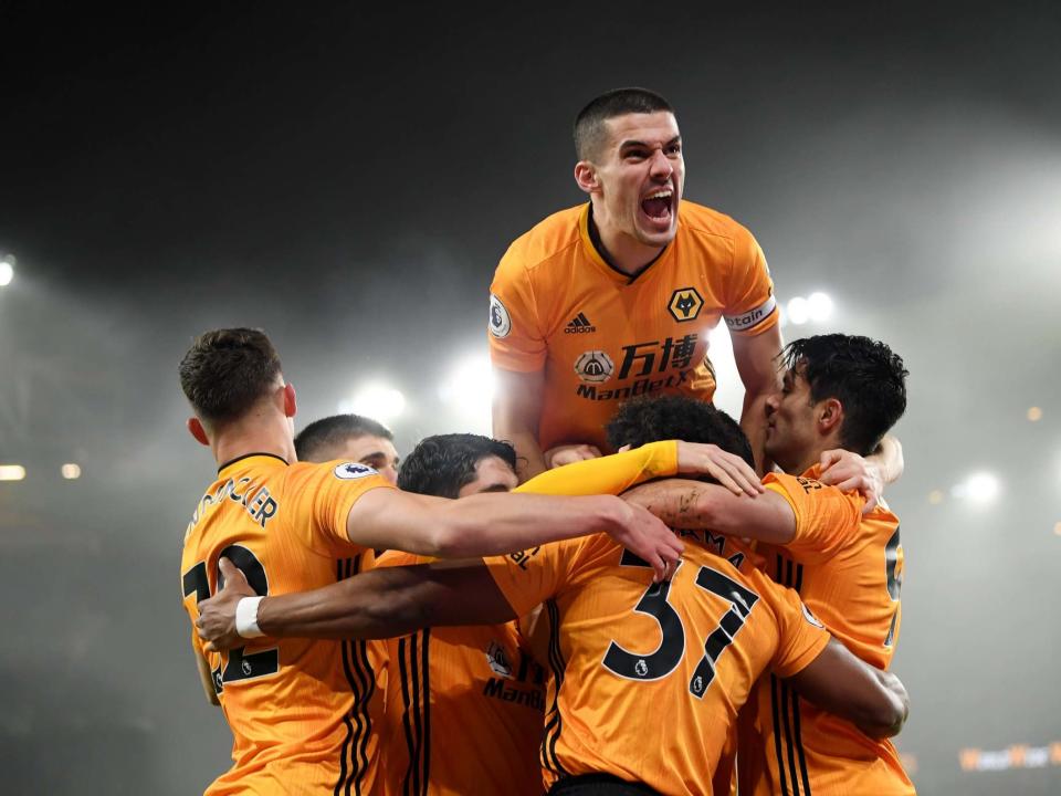 Conor Coady of Wolverhampton Wanderers jumps on his teammates as they celebrate Raul Jimenez scoring: Getty Images