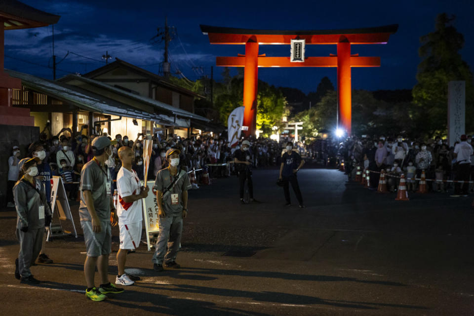 2021年6月25日，日本富士宮舉行的東京奧運會火炬傳遞期間，一名火炬手在接力點等待。