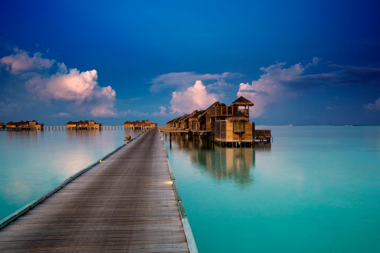 a dock leading to a building on a body of water
