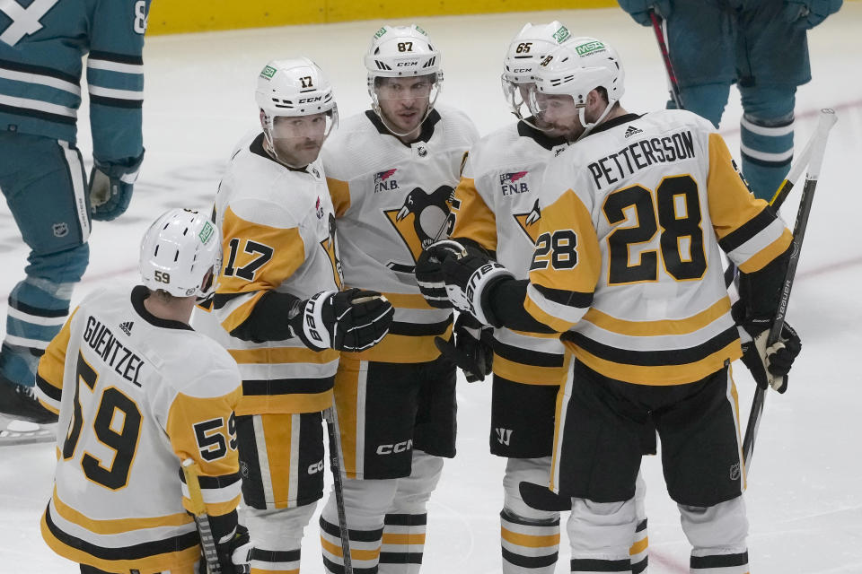 Pittsburgh Penguins right wing Bryan Rust (17) celebrates with left wing Jake Guentzel (59), center Sidney Crosby, defenseman Erik Karlsson, and defenseman Marcus Pettersson (28) after scoring during the third period of an NHL hockey game against the San Jose Sharks in San Jose, Calif., Saturday, Nov. 4, 2023. (AP Photo/Jeff Chiu)