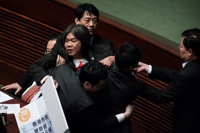 Hong Kong lawmaker Leung Kwok-hung is escorted out of the legislative chamber after disrupting a policy address by Hong Kong Chief Executive Leung Chun-ying (not in picture) on January 16, 2013. Leung has unveiled a raft of populist policies with an emphasis on tackling the city's housing crisis, as he aimed to hush critics' repeated calls to step down