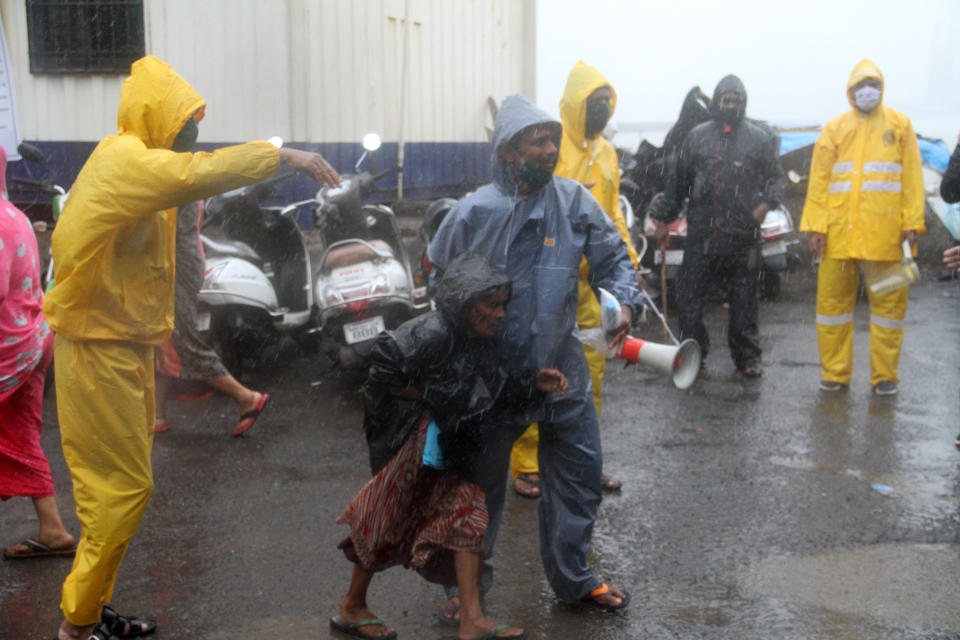 MUMBAI, INDIA - JUNE 03: Indian Police officers help a woman before Cyclone Nisarga hits Mumbai, India on June 03, 2020. A storm in the Arabian Sea off India's west coast intensified into a severe cyclone on Wednesday, gathering speed as it barreled toward India's financial capital of Mumbai. Nisarga was forecast to drop heavy rains and winds gusting up to 120 kilometers (75 miles) per hour when it makes landfall Wednesday afternoon as a category 4 cyclone near the coastal city of Alibagh, about 98 kilometers (60 miles) south of Mumbai, India's Meteorological Department said. (Photo by Imtiyaz Shaikh/Anadolu Agency via Getty Images)