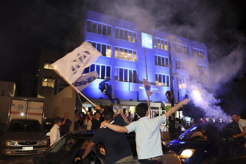 Supporters of Kyriakos Mitsotakis leader of the center-right New Democracy celebrate outside the headquarters of the party in Athens, Greece, Sunday, June 25, 2023. Greece's conservative New Democracy party leader Kyriakos Mitsotakis has vowed to speed up reforms following his landslide victory in the country's second election in five weeks. Near complete results Sunday show him gaining a comfortable parliamentary majority to form a government for a second four-year term. (AP Photo/Yorgos Karahalis)