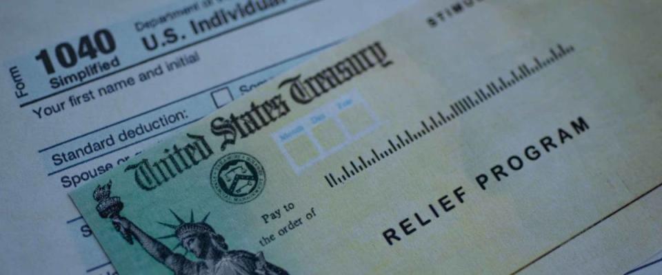 Form 1040 U.S. Individual Income tax return next to the Stimulus Check Relief program. Close up view.