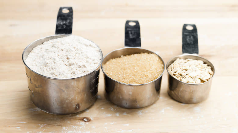 Oats and flour in measuring cups